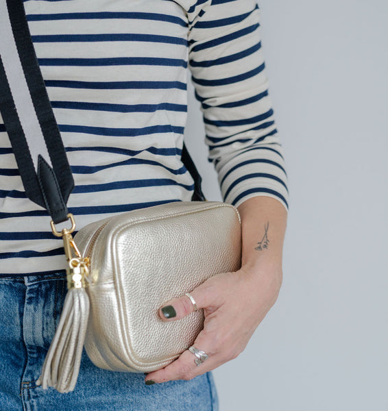 Gold Leather Tassel Cross Body Bag with monochrome strap carried by Laura AnySomething Photography